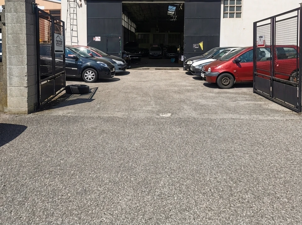 Atelier de réparation automobile avec mécaniciens en combinaison travaillant sur véhicules, capots ouverts