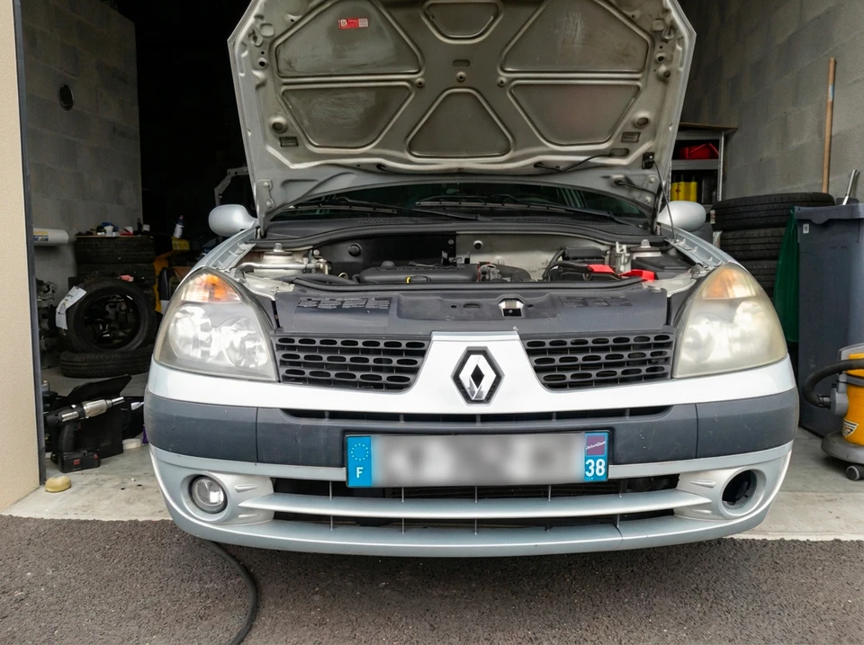 Mécanicien automobile utilisant un ordinateur portable pour diagnostic véhiculaire dans un garage professionnel