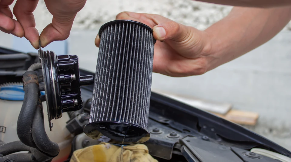 Main du filtre à air de voiture de retenue mécanique vieux et sale avec des taches de poussière pour vérifier le nettoyage et remplacer le nouveau filtre