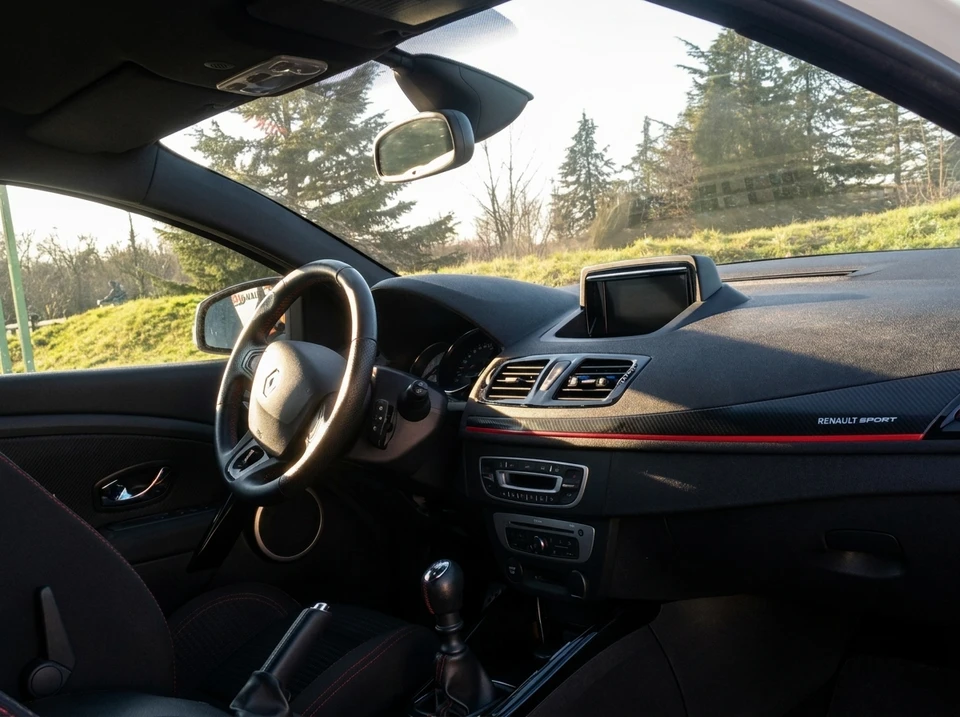 Atelier de réparation automobile moderne avec mécanicienne professionnelle en combinaison bleue et lunettes de sécurité consultant une tablette numérique