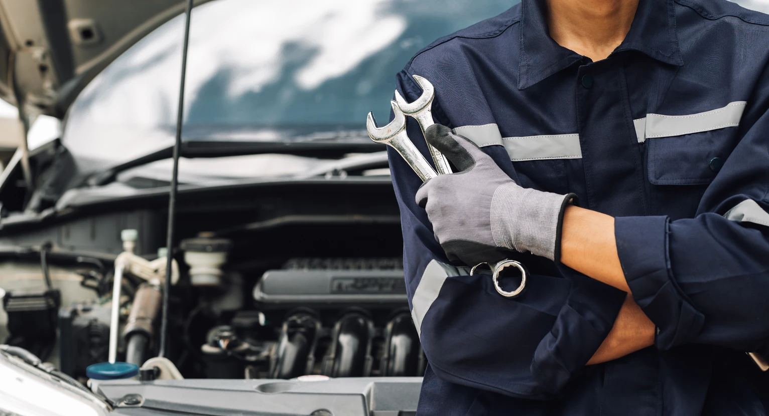 Mécanicien automobile en combinaison bleue gonflant un pneu dans un garage professionnel